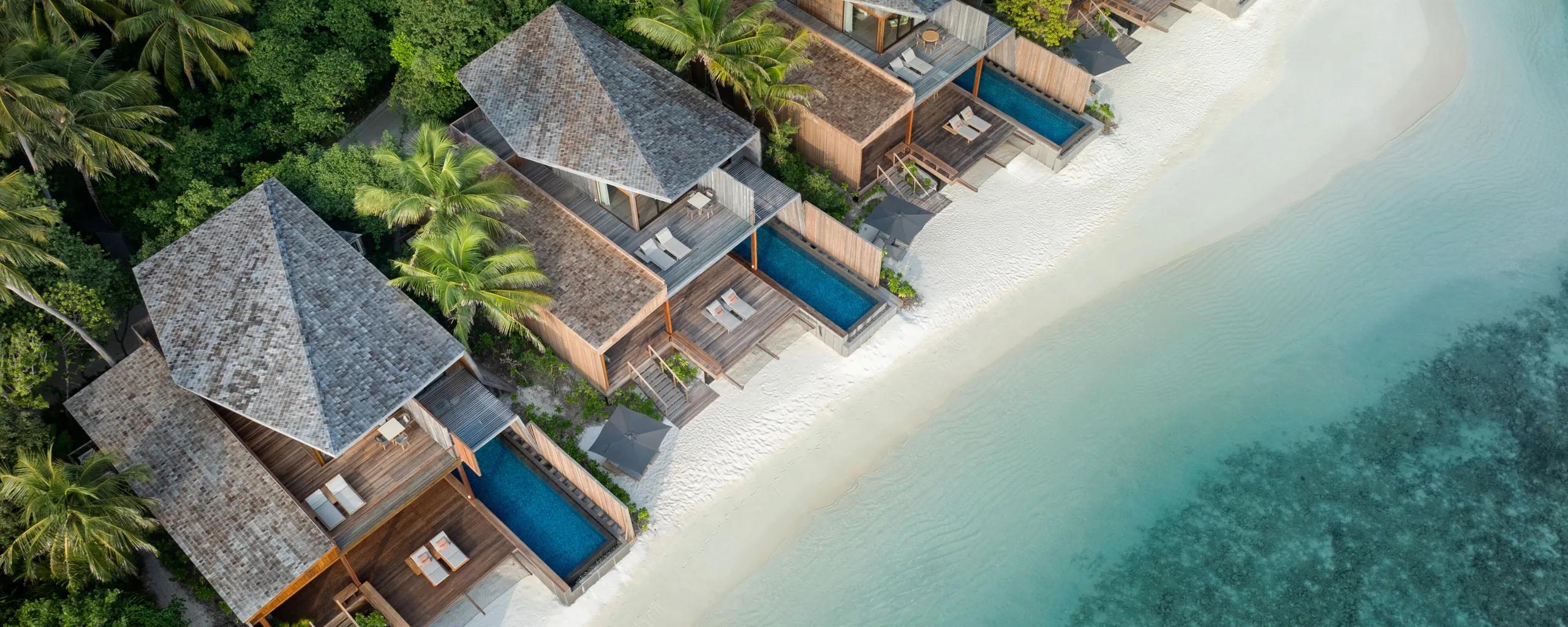 Aerial view of The St. Regis Maldives Vommuli Resort's overwater villas set against the reef in Dhaalu Atoll