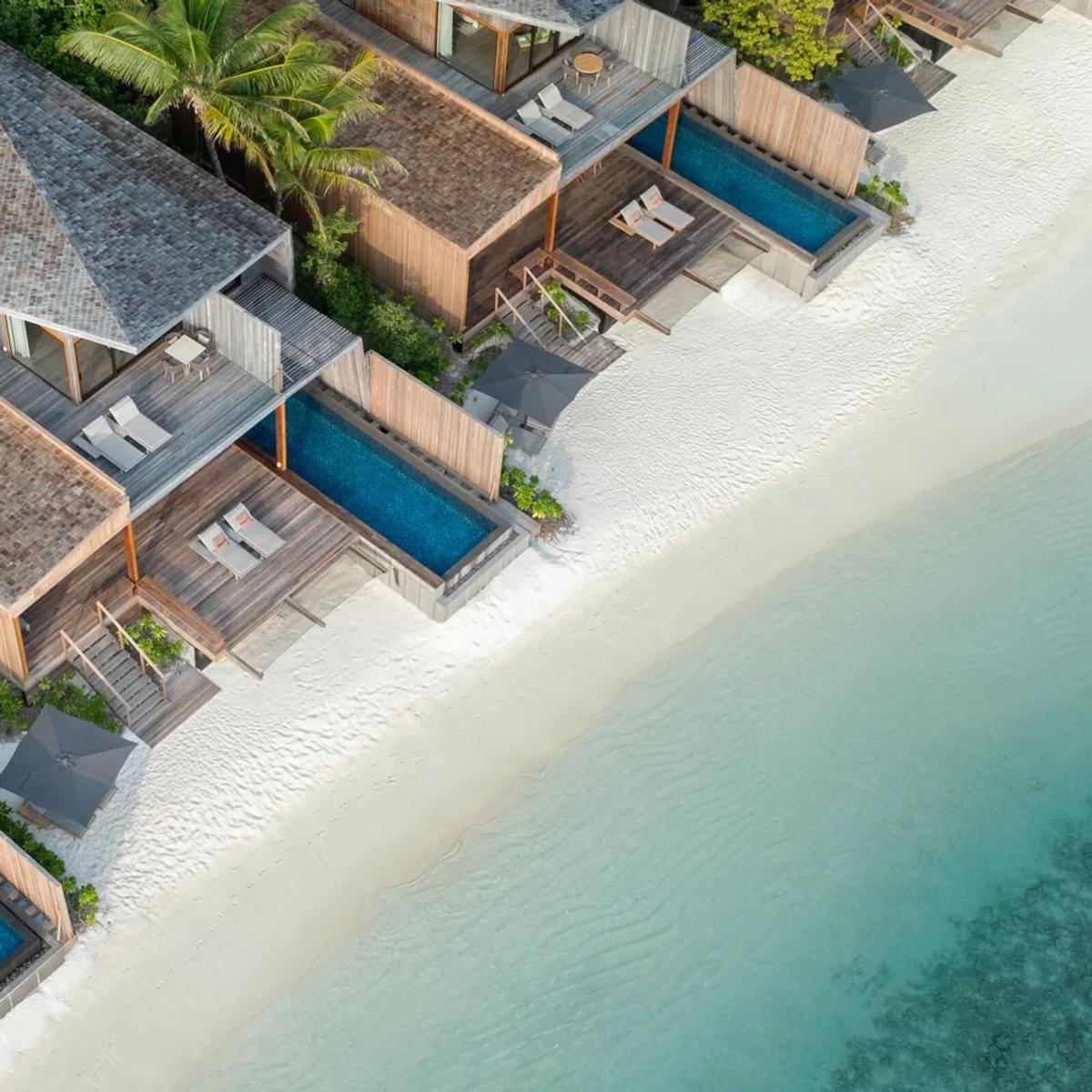 Aerial view of The St. Regis Maldives Vommuli Resort's overwater villas set against the reef in Dhaalu Atoll