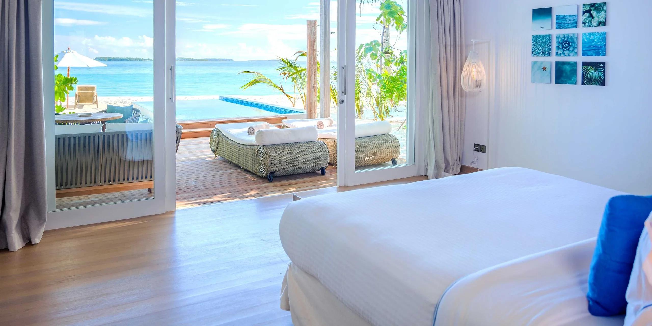 A Sunset Beach Villa with Pool's bedroom opening onto its private plunge pool and beachfront sun loungers