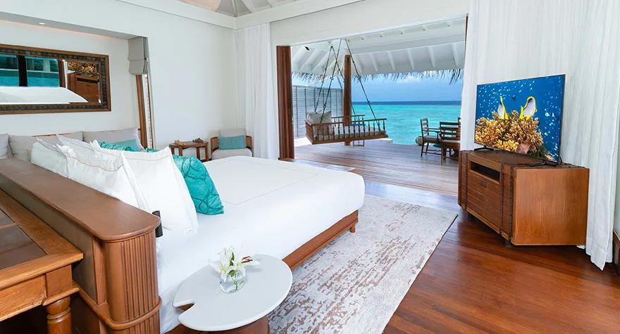 Bedroom of an Over Water Pool Villa at Anantara Kihavah, opening onto the lagoon