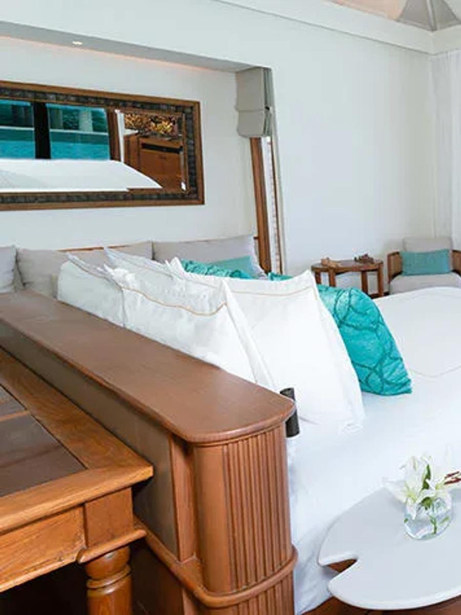 Bedroom of an Over Water Pool Villa at Anantara Kihavah, opening onto the lagoon