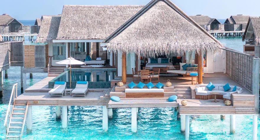 An Over Water Pool Villa's deck and private pool at Anantara Kihavah, overwater villas lining the jetty beyond