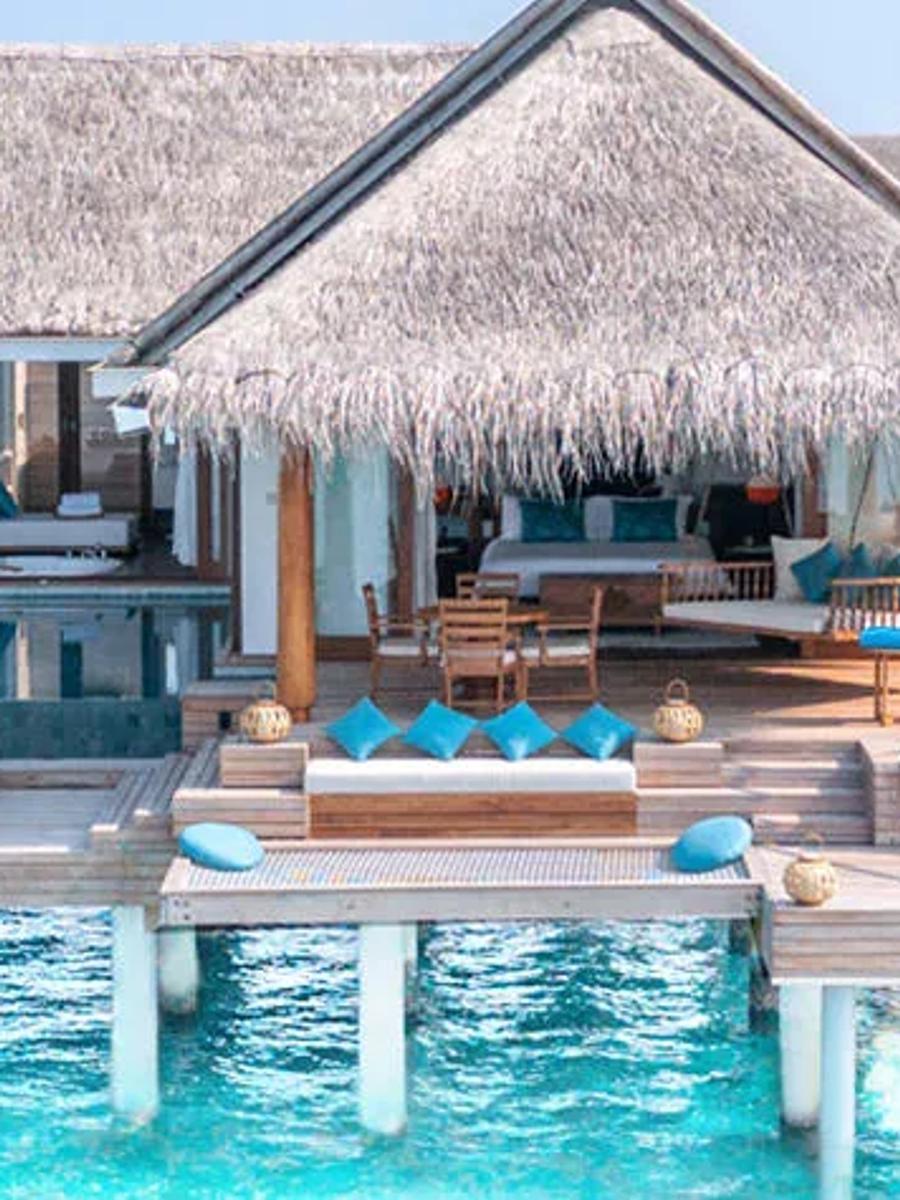 An Over Water Pool Villa's deck and private pool at Anantara Kihavah, overwater villas lining the jetty beyond