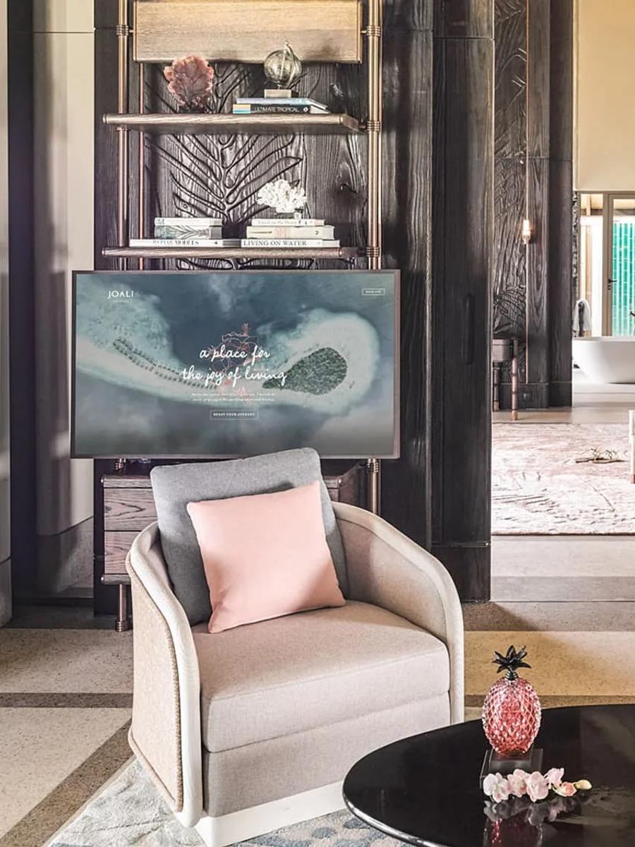 The living area of a Luxury Sunset Water Villa with Pool, opening onto an ensuite with a freestanding tub