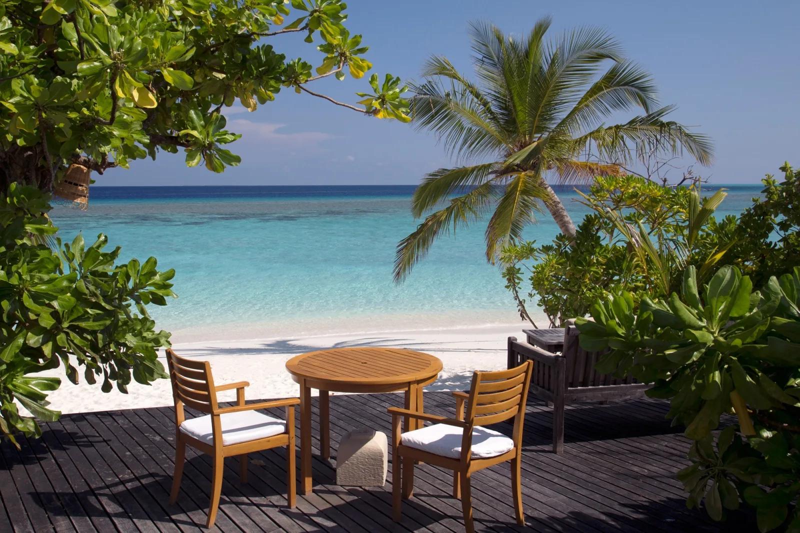 A table for two on Conch Bar's shaded deck, the lagoon visible through the palms
