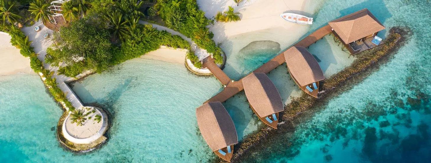 Aerial view of ELE | NA's overwater treatment room jetty extending from the beach over the reef