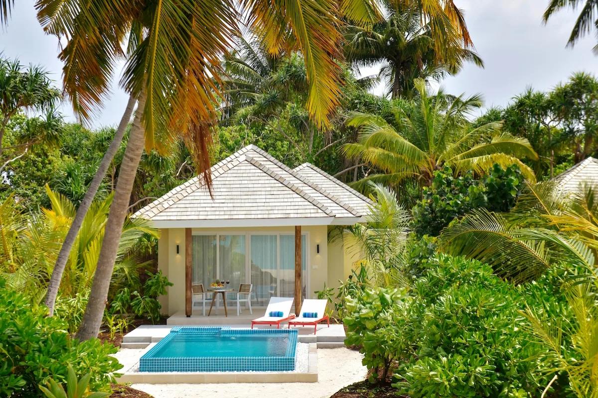 A Sunrise Beach Pool Villa's private swirl pool and sun loungers among palm trees