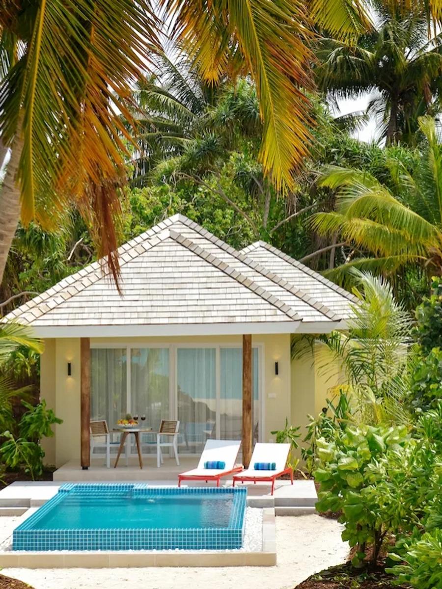A Sunrise Beach Pool Villa's private swirl pool and sun loungers among palm trees
