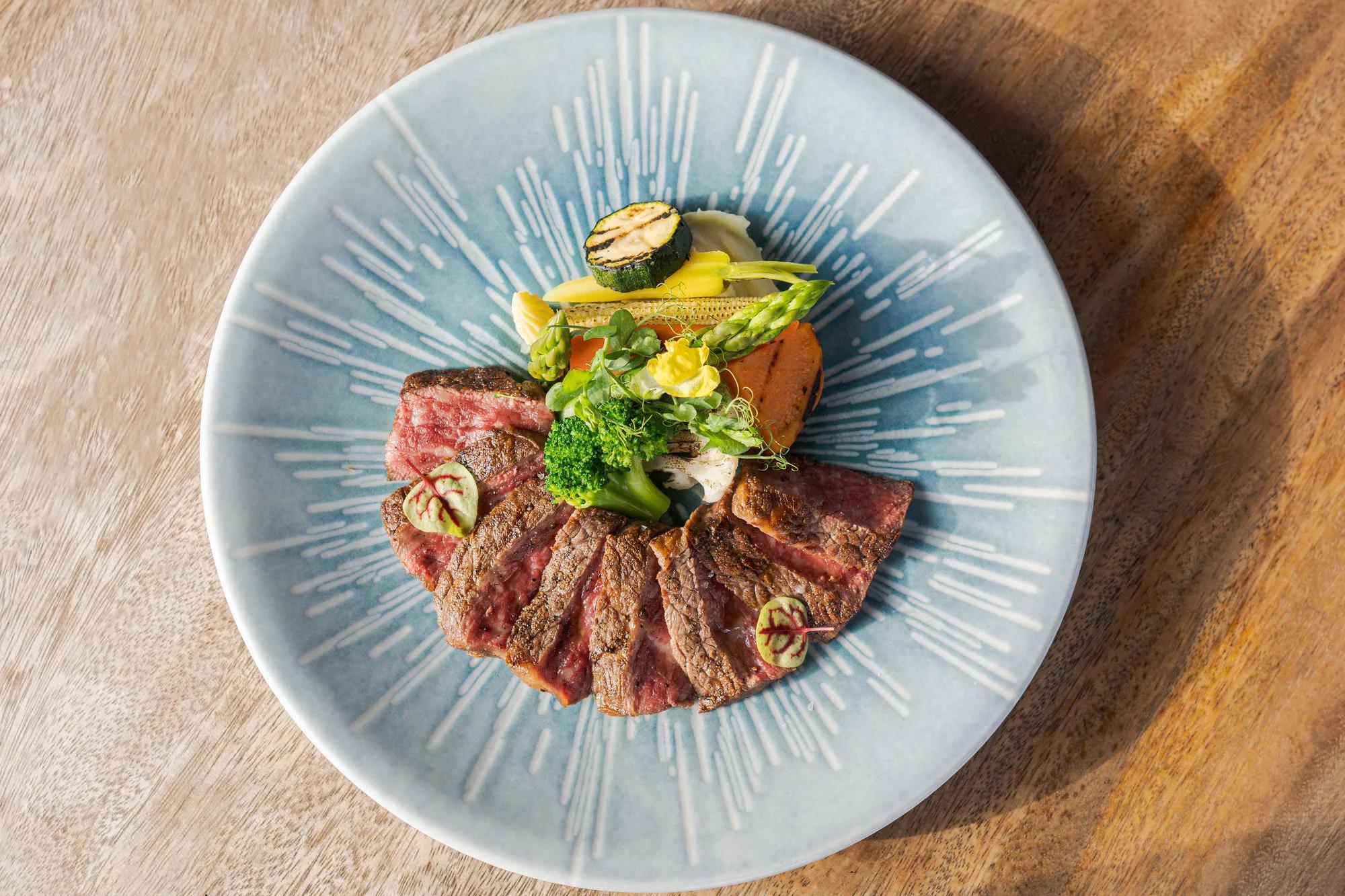 A seared, sliced beef dish with grilled vegetables at Saoke, JOALI's Japanese restaurant