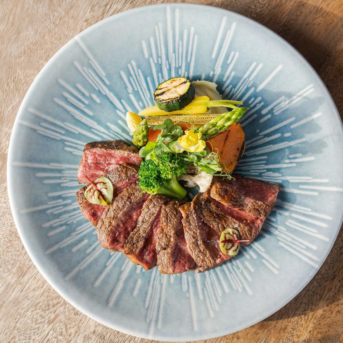 A seared, sliced beef dish with grilled vegetables at Saoke, JOALI's Japanese restaurant