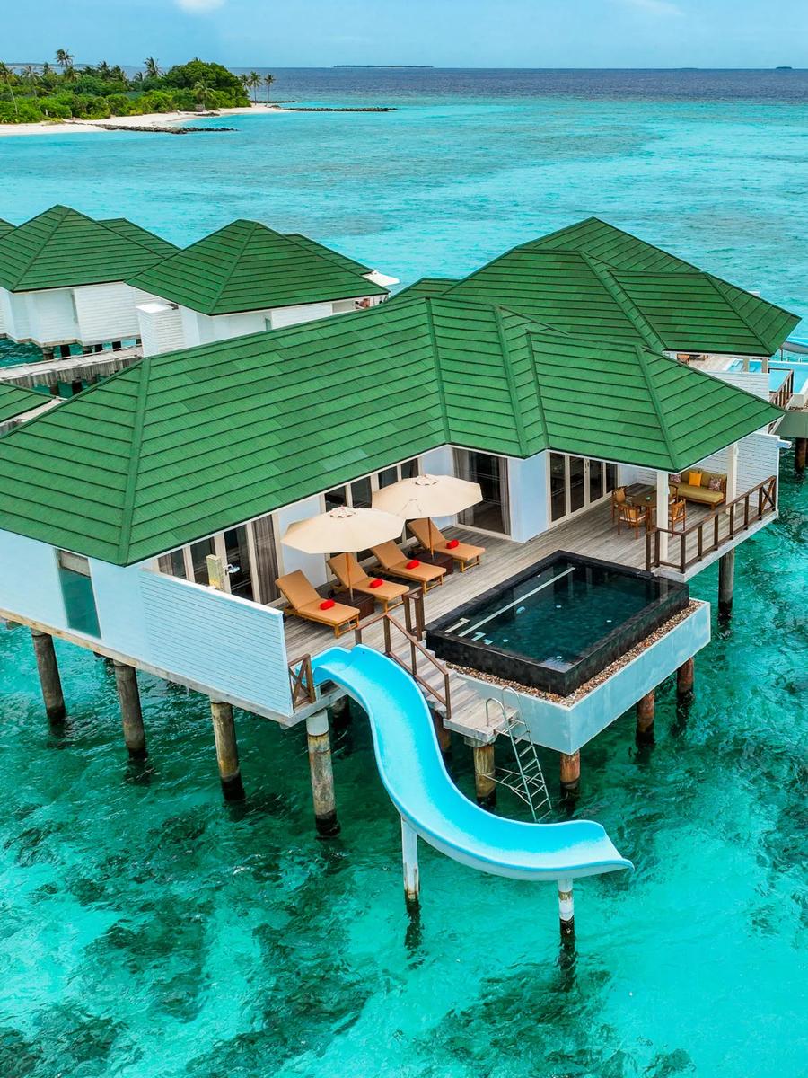 Overwater villas with pools and slides reaching into the lagoon at Siyam World
