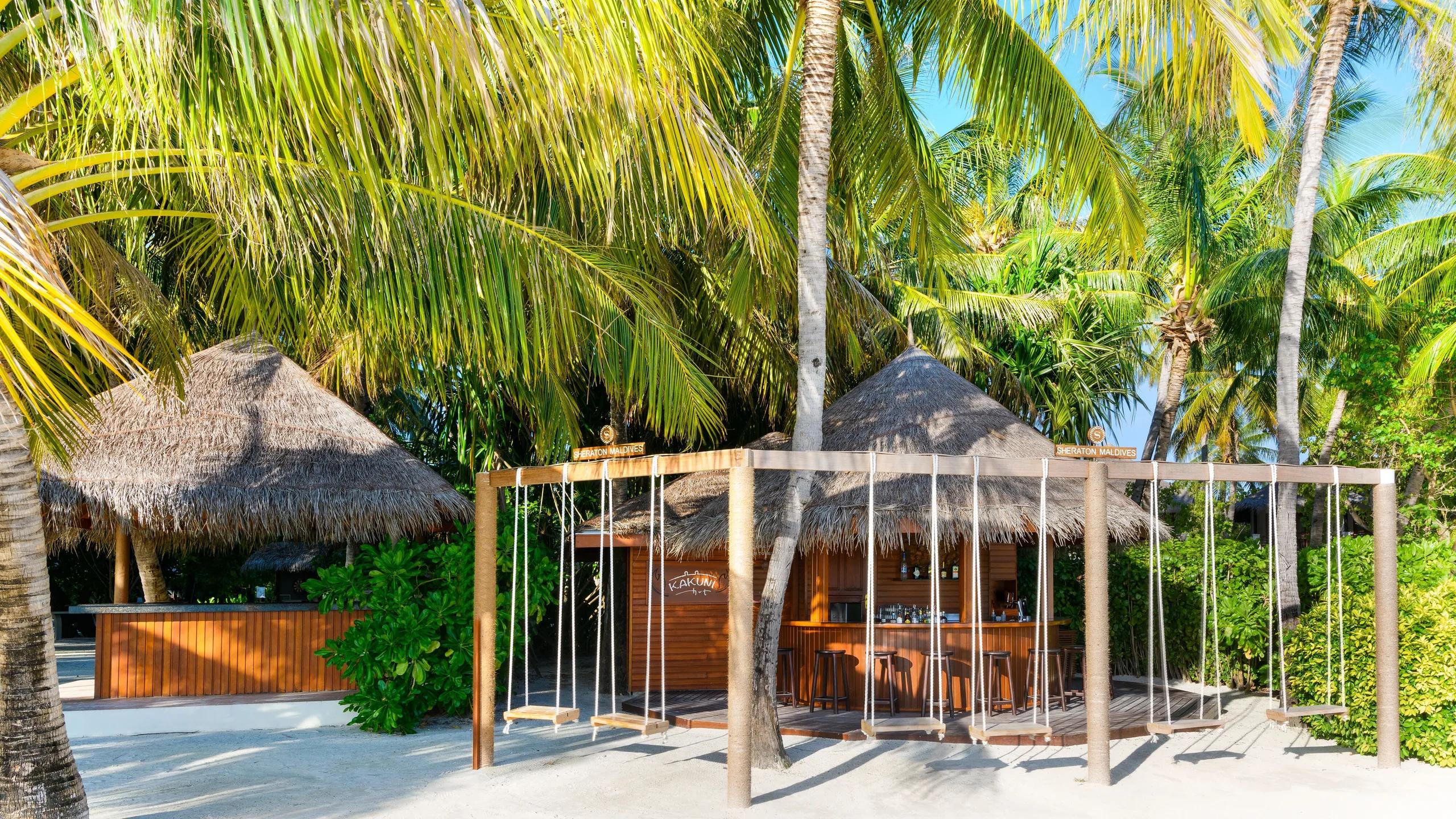 Kakuni Hut's beachfront bar, with its signage over the counter and rope swings strung along the sand
