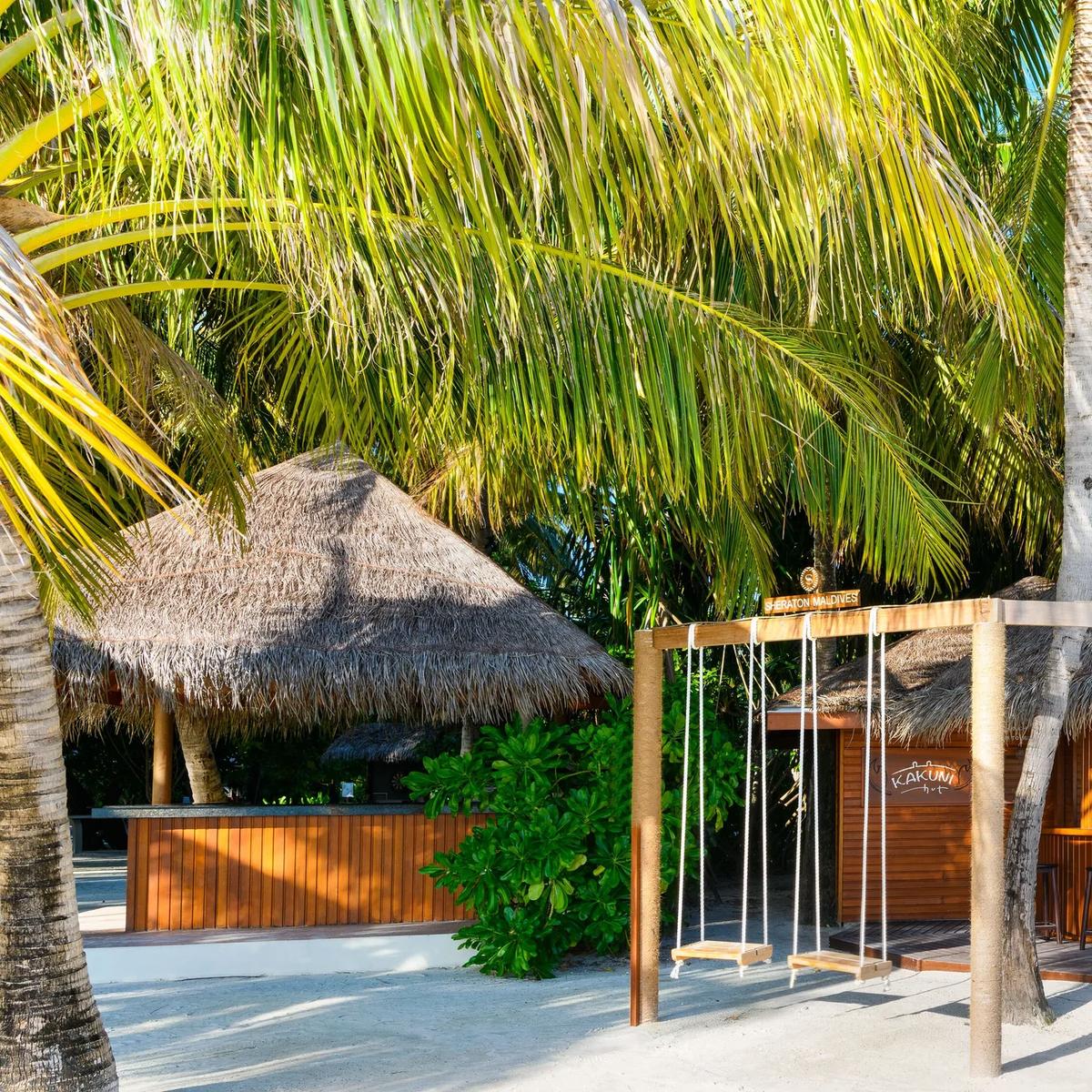 Kakuni Hut's beachfront bar, with its signage over the counter and rope swings strung along the sand