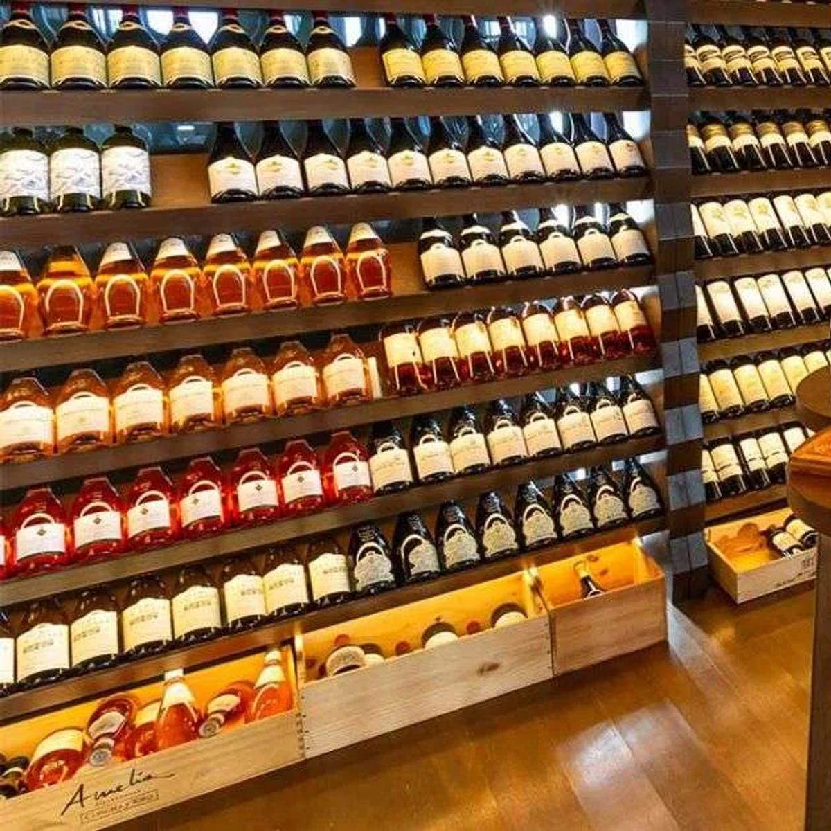 Floor-to-ceiling wine racks in Kudadoo's Wine Cellar, bottles staged for tasting on a central table