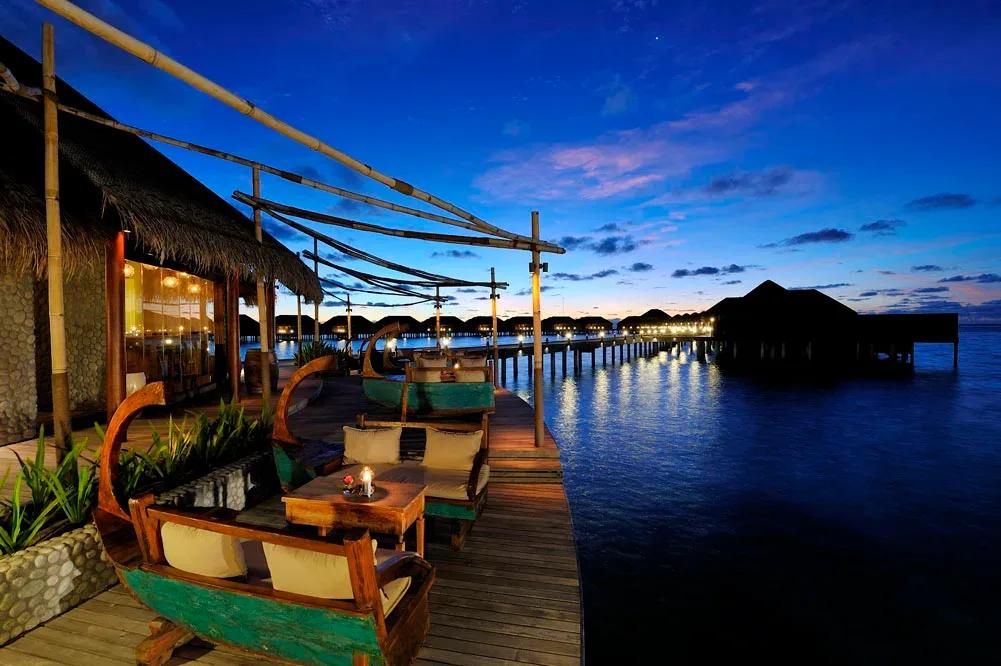 Ile de Joie's jetty of boat-shaped daybeds, strung out over the lagoon at dusk