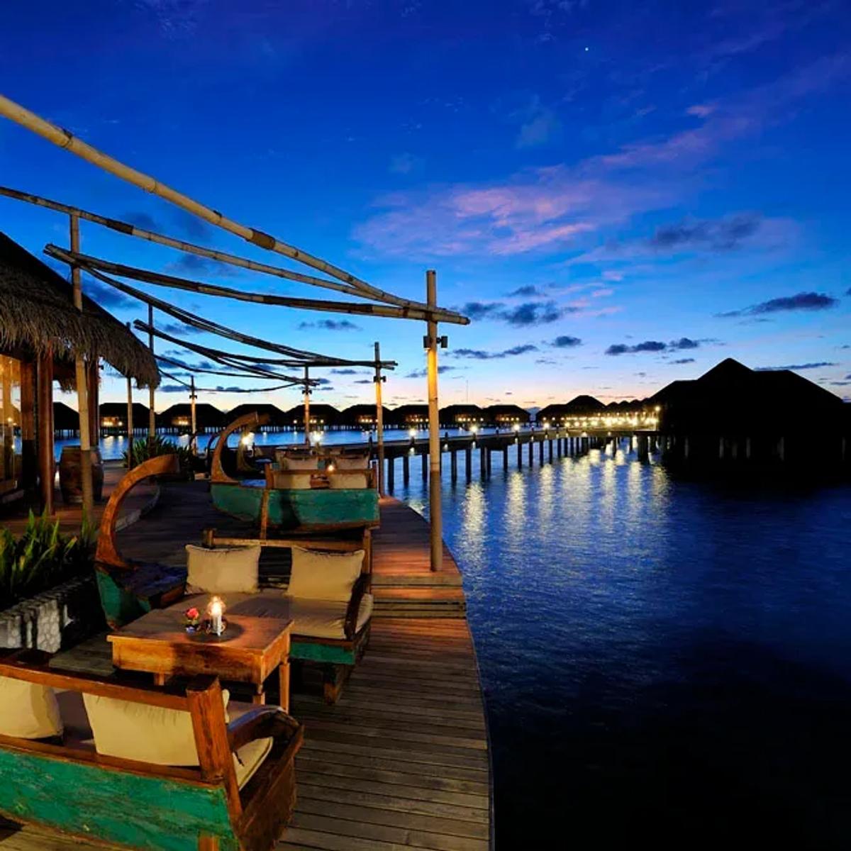 Ile de Joie's jetty of boat-shaped daybeds, strung out over the lagoon at dusk