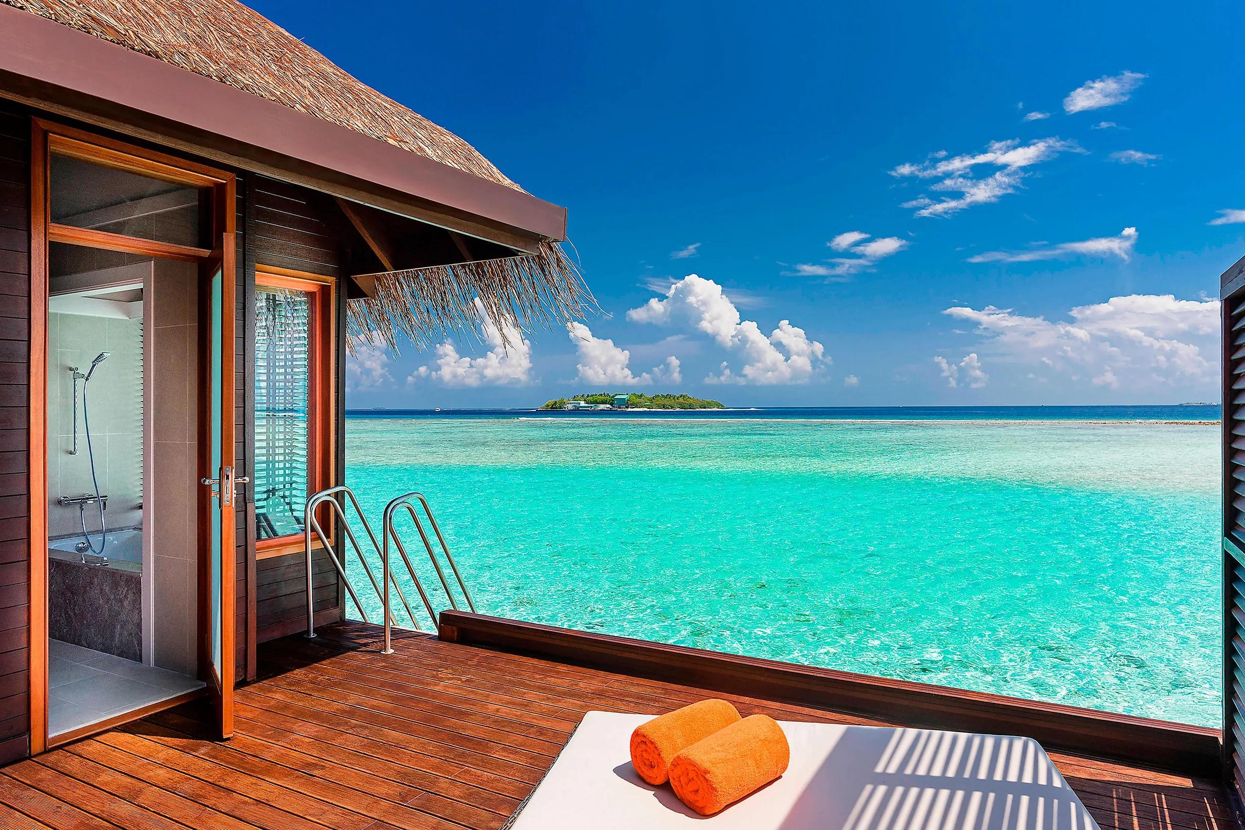 Overwater Villa deck with a ladder down into the lagoon and a neighbouring island visible on the horizon