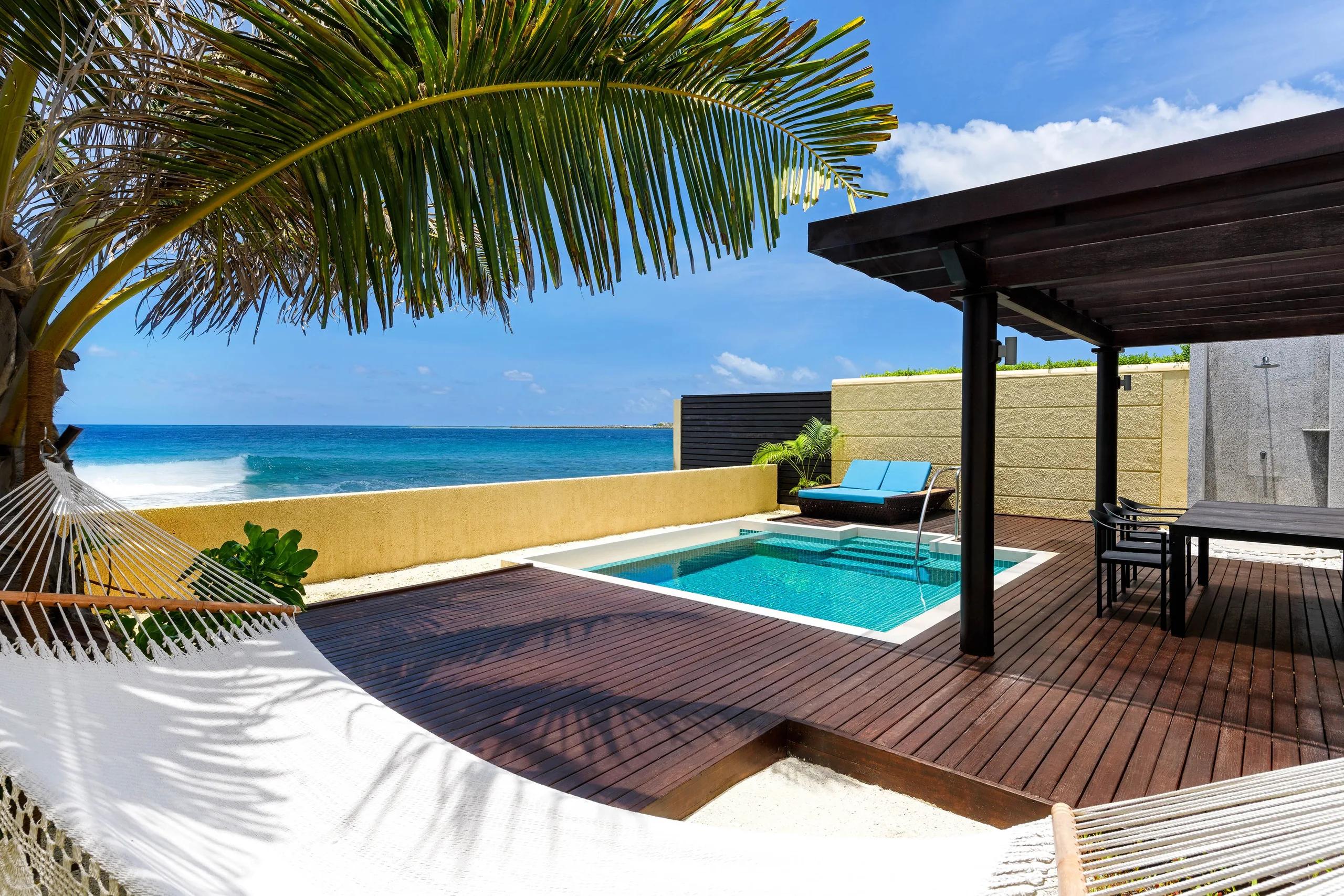 Ocean Villa's private plunge pool and sun deck, with a hammock and direct ocean views over the reef break