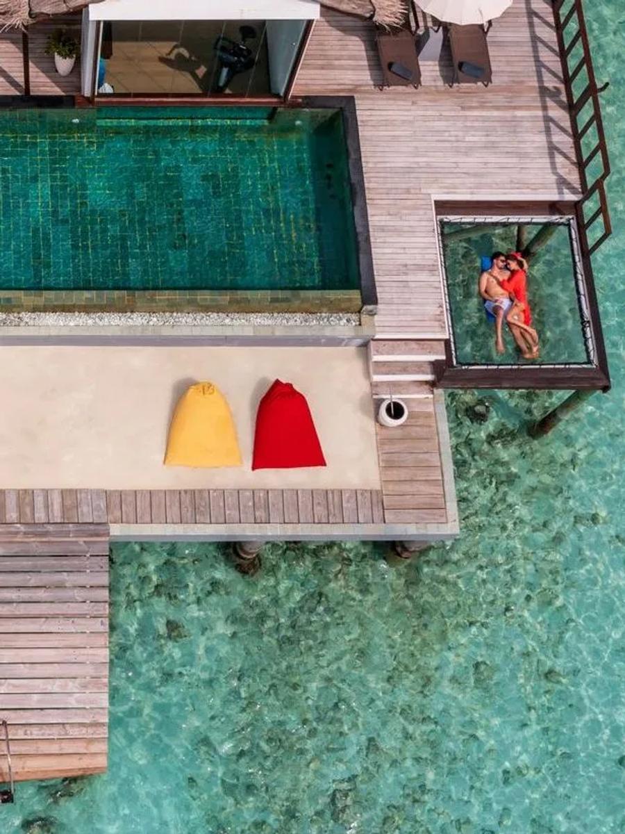 Aerial view of THE OZEN RESIDENCE's overwater pool, glass floor panels set into the sundeck on either side