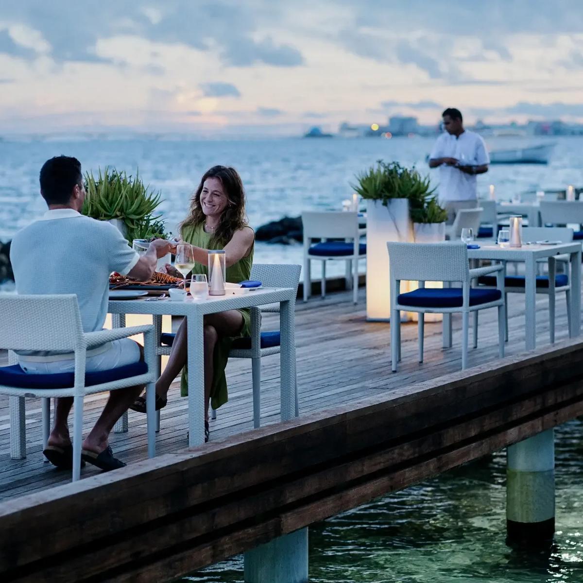 Thila's dining tables set over the water at Niva Kurumba