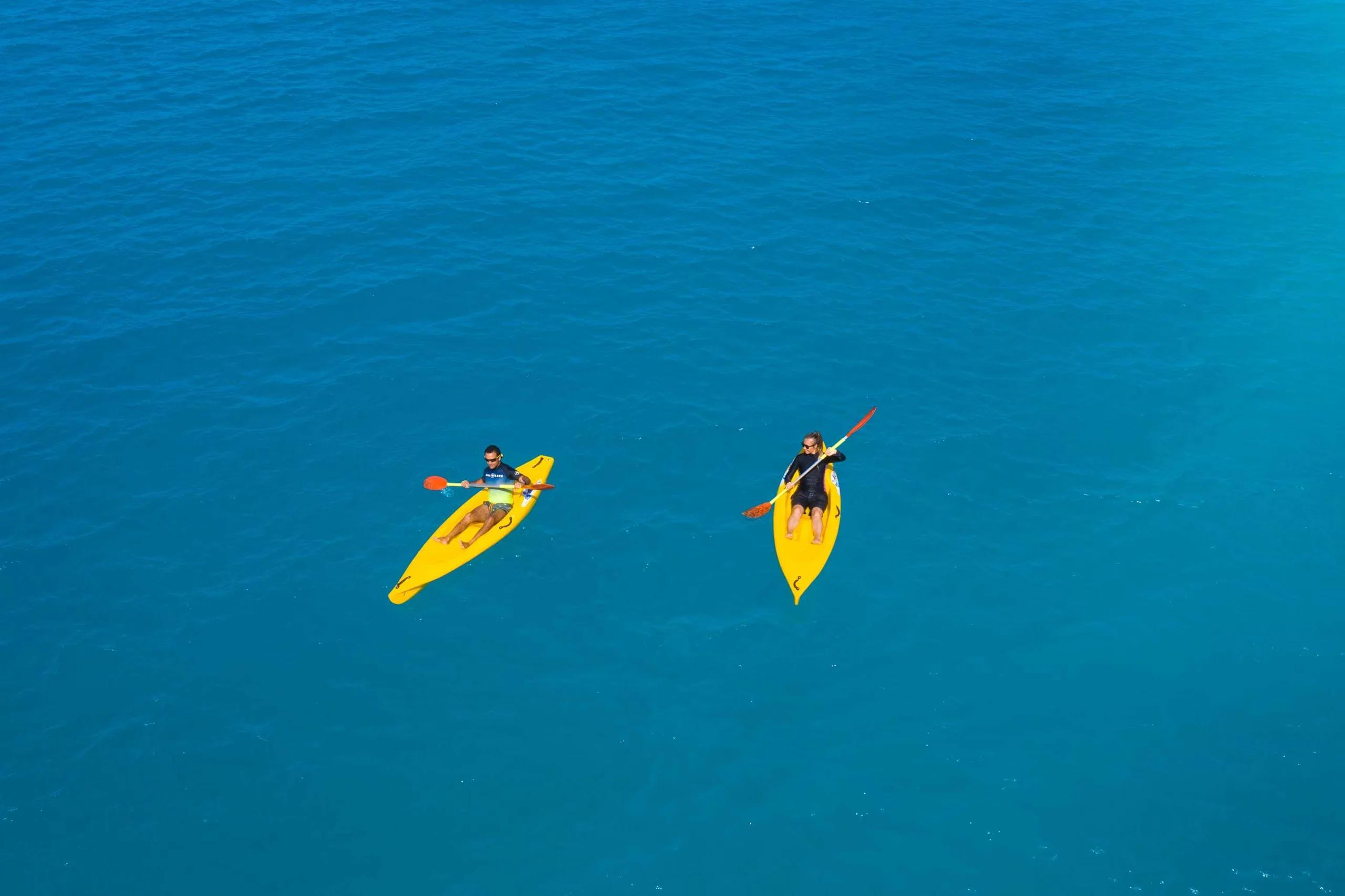 Two kayakers on open water near Radisson Blu Resort Maldives, seen directly from above