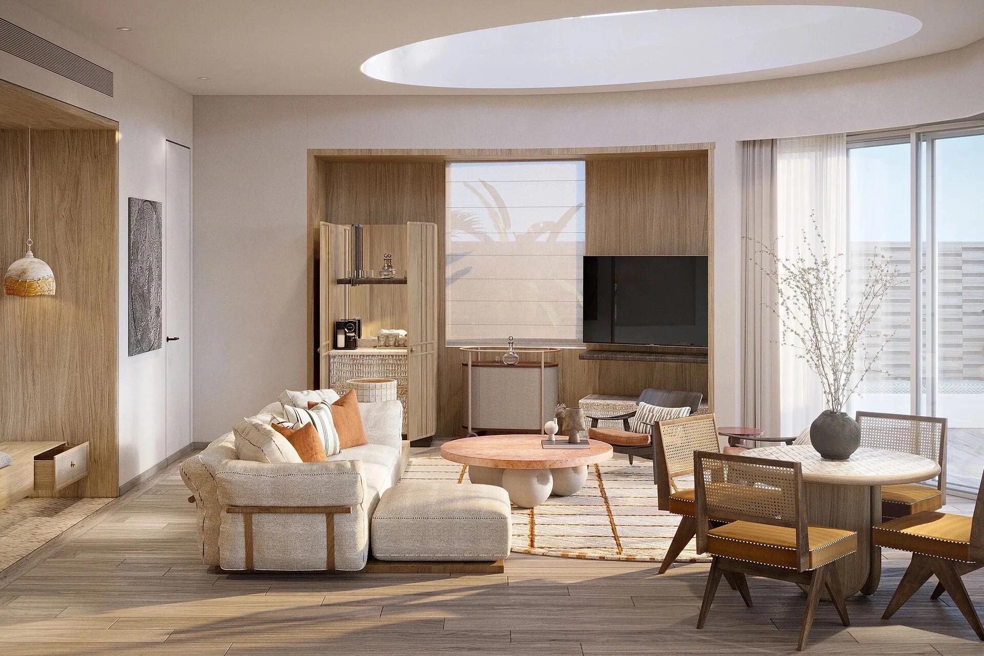 The living area of a One Bedroom Grand Lagoon Villa at Jumeirah Olhahali, with a curved skylight, wet bar and dining nook