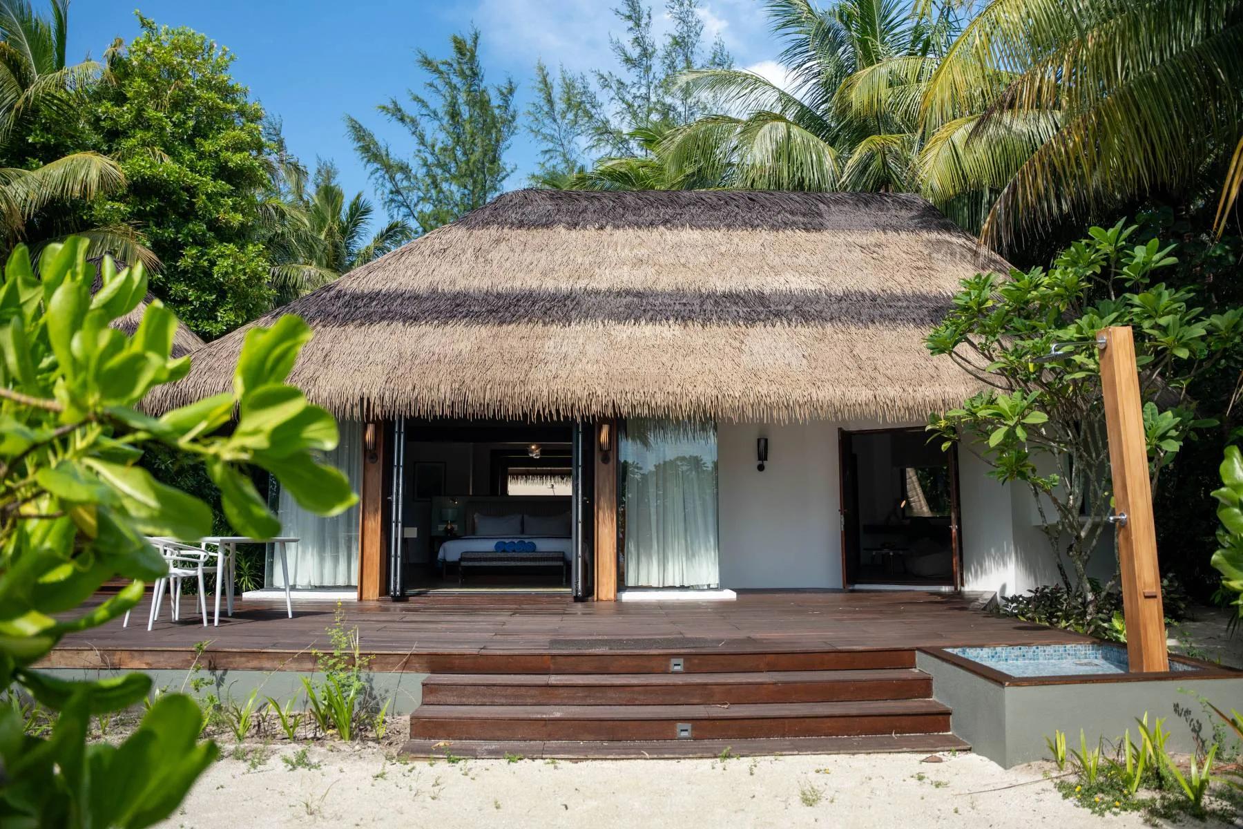 The exterior of a Family Beach Villa set among trees near the shoreline