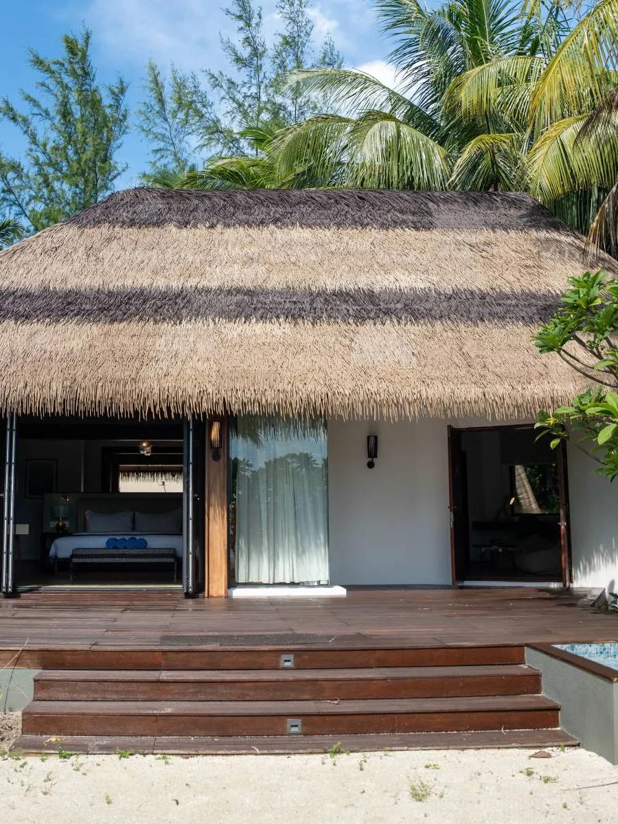 The exterior of a Family Beach Villa set among trees near the shoreline