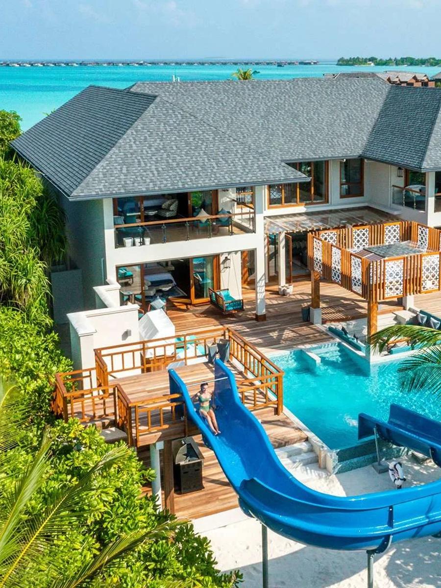 Aerial view of the Four-Bedroom Sultan Beach Residence, its water slide curving into the private pool