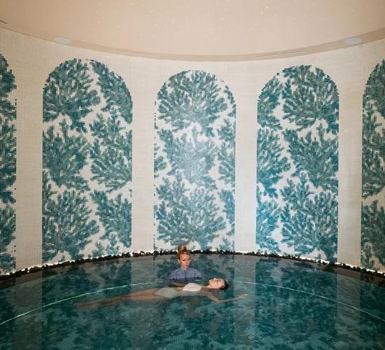 A guest floated in warm water during a Watsu session in KAASHI's hydrotherapy pool at Joali Being