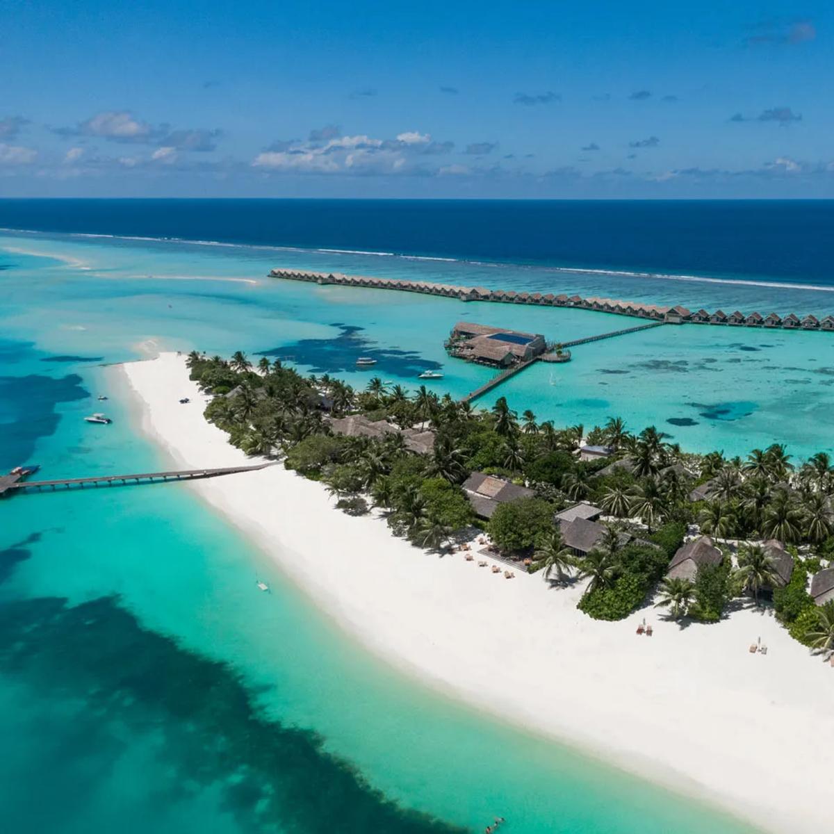 The resort's beach and overwater jetty seen from the air