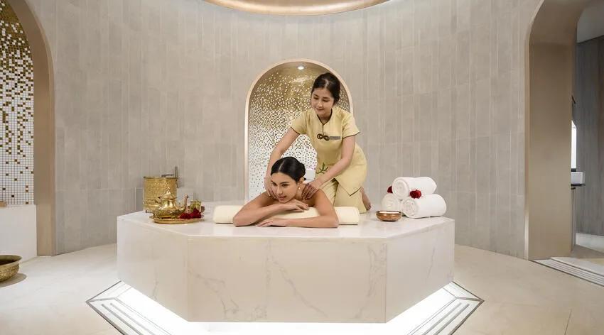 A guest receiving a back massage on a marble treatment table at SPA Cenvaree
