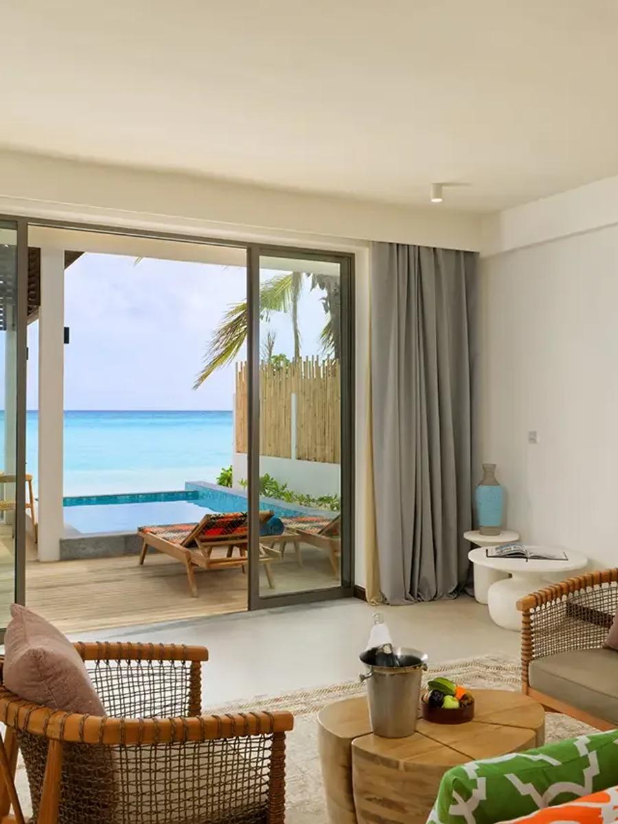 A Beach Pool Suite's bedroom opening onto its terrace and plunge pool