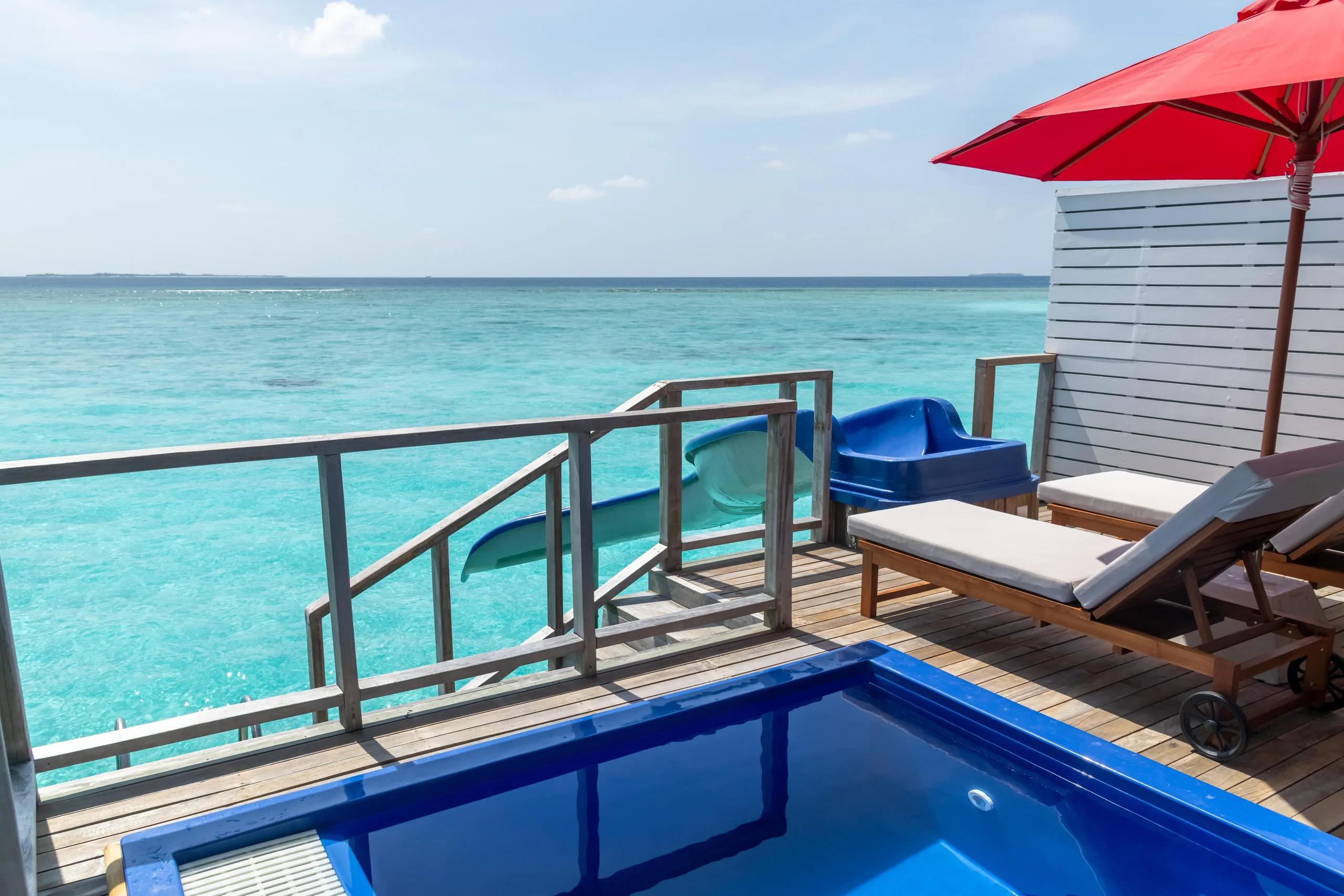 A Water Villa's private pool and slide reaching out over the lagoon at Siyam World