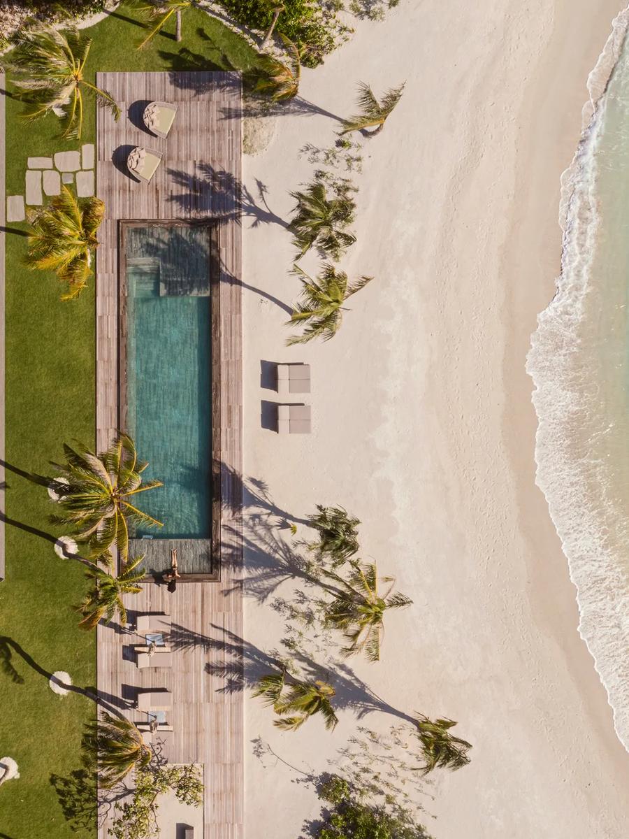 An aerial view of The Beach House, its plunge pool and lawn running from the villa to a private stretch of beach