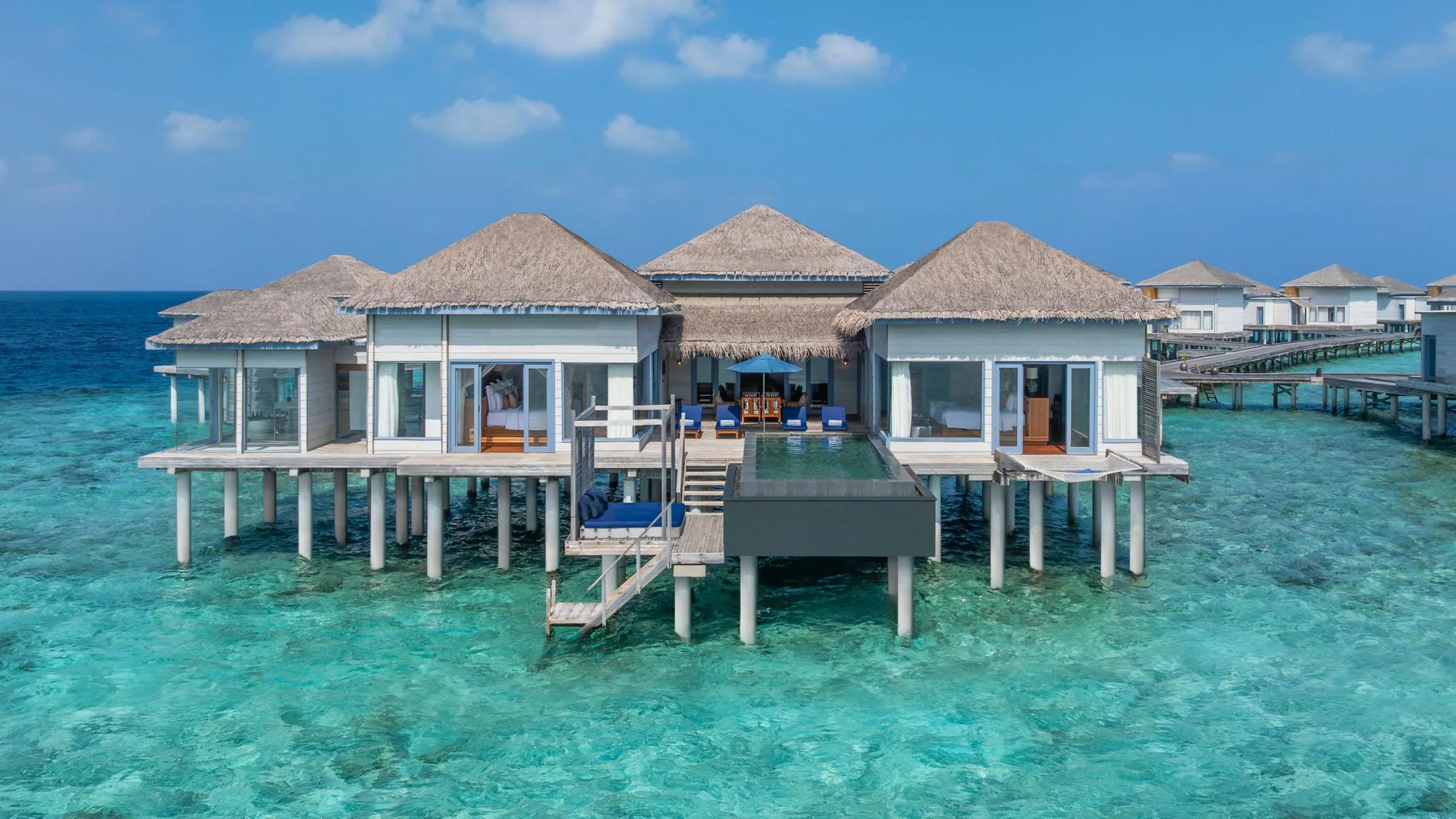 A Two-Bedroom Villa seen from above, its infinity pool reaching toward the lagoon