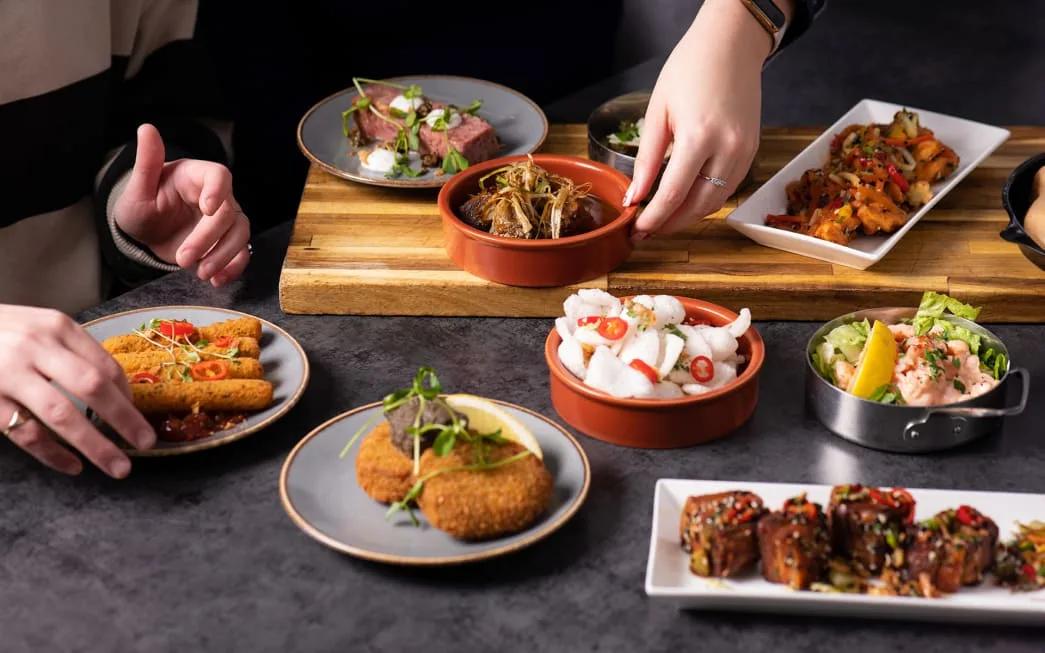 A spread of tapas dishes including seared beef, crab cakes and prawns at Dhoni Bar