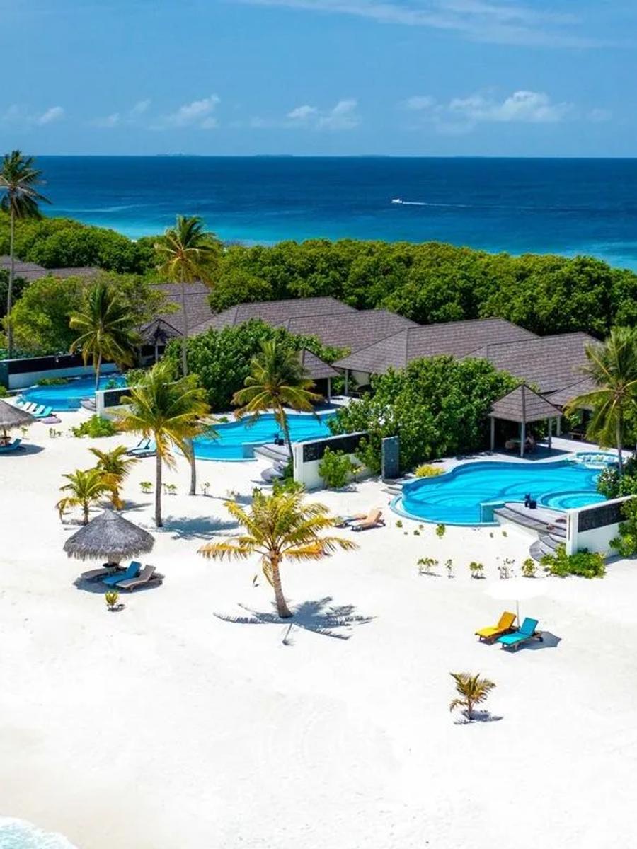 An aerial view along Atmosphere Kanifushi's beachfront pool villas, including the resort's largest private-pool categories