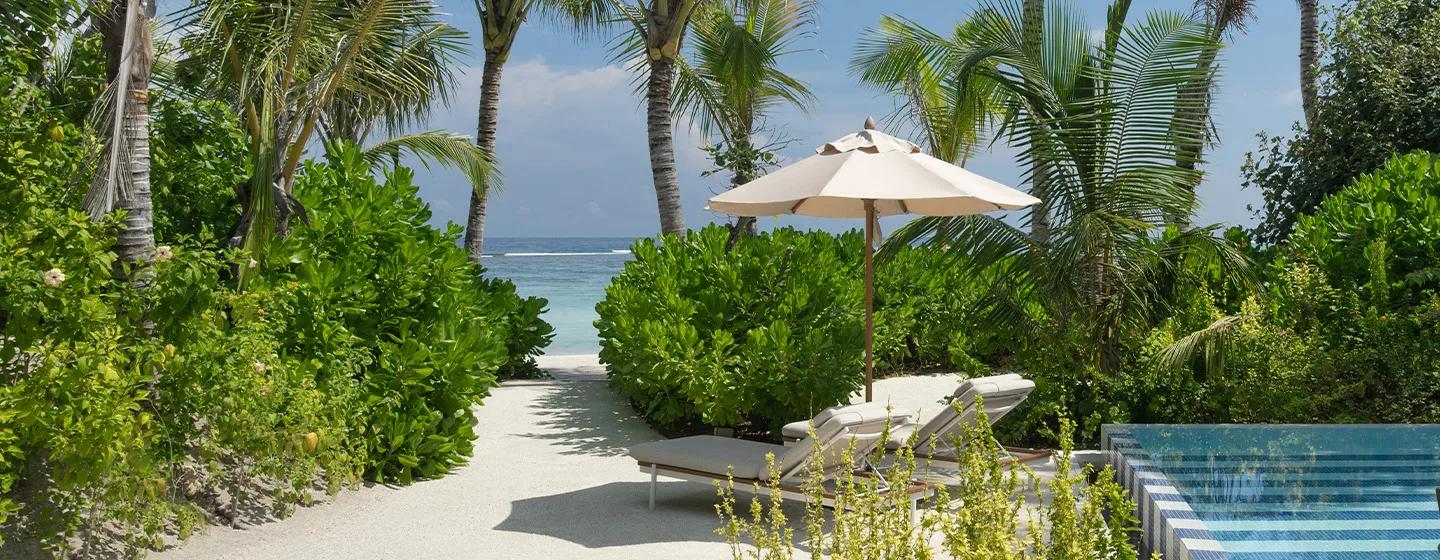 A sandy path lined with hibiscus and palms leading from a beach villa's pool deck to the shore at SO/ Maldives — representative of the Beach Pool Villa category; a dedicated single-villa photograph was not available