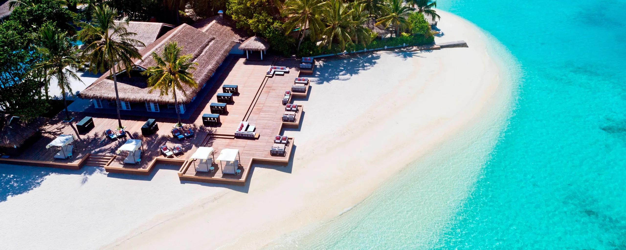 Aerial view of Anchorage's beachfront deck and sun loungers, where the island's beach curves toward open water