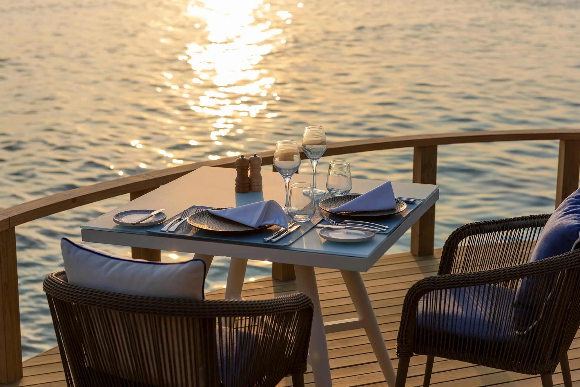 Mediterraneo Restaurant's overwater dining room, tables set for the evening above the lagoon