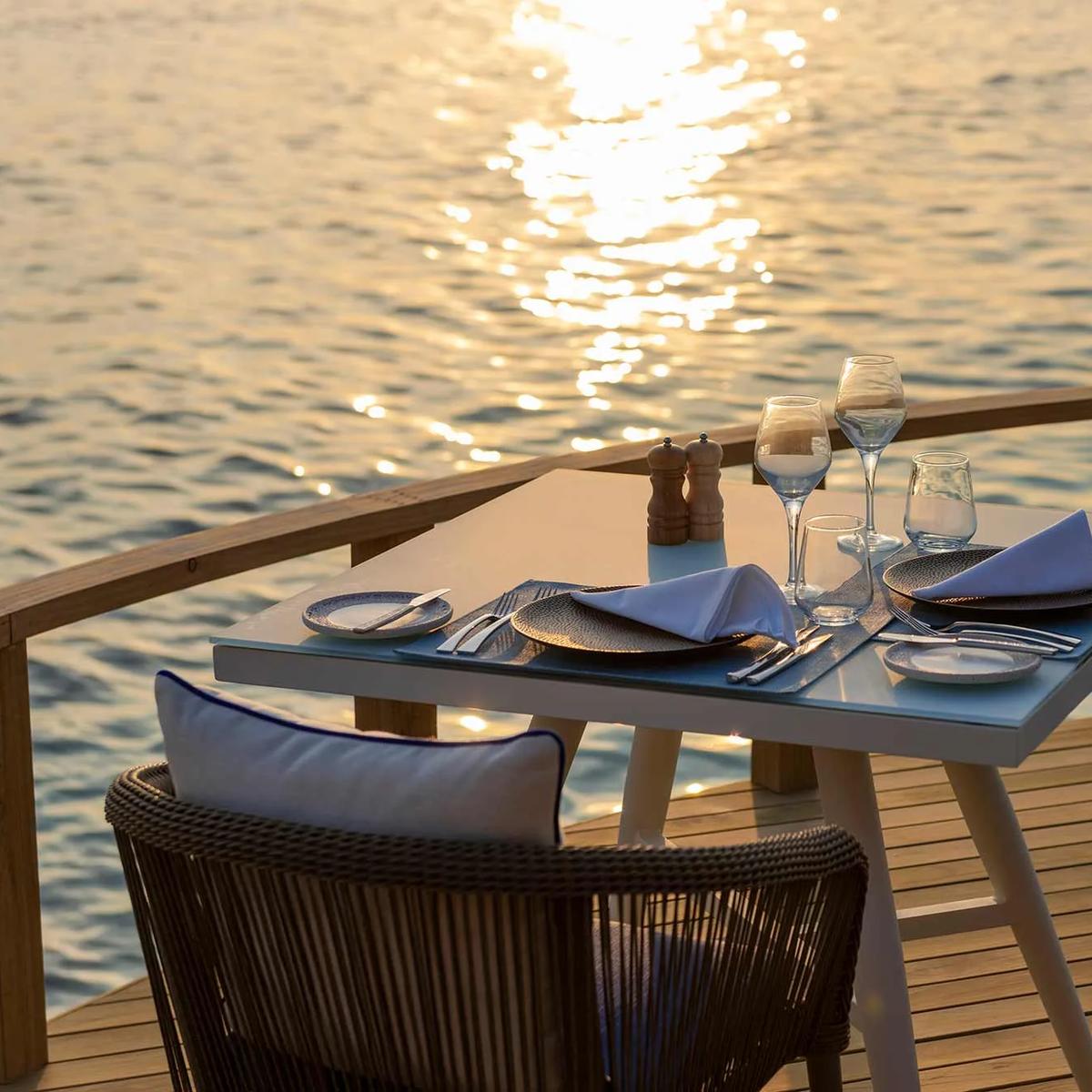 Mediterraneo Restaurant's overwater dining room, tables set for the evening above the lagoon
