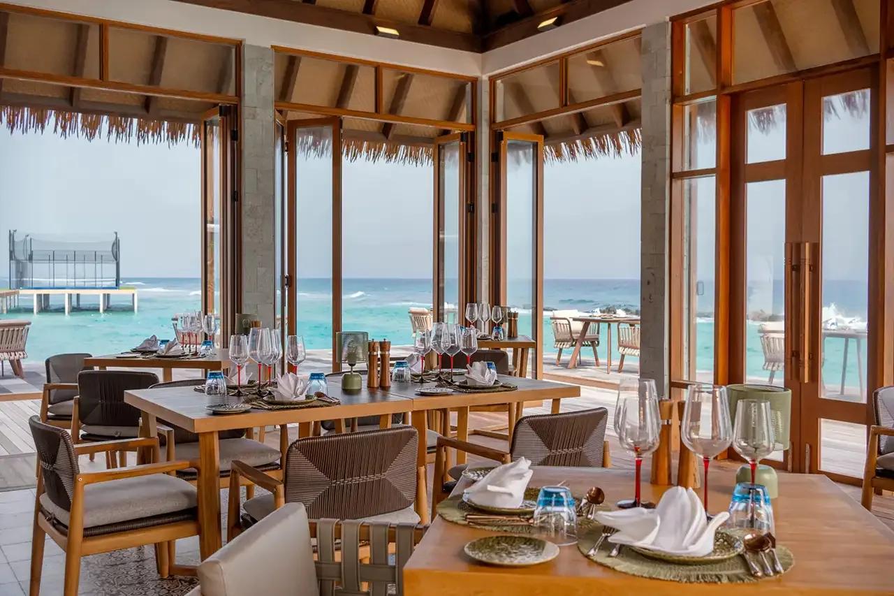 Alif's open-air dining pavilion, tables set with an ocean view