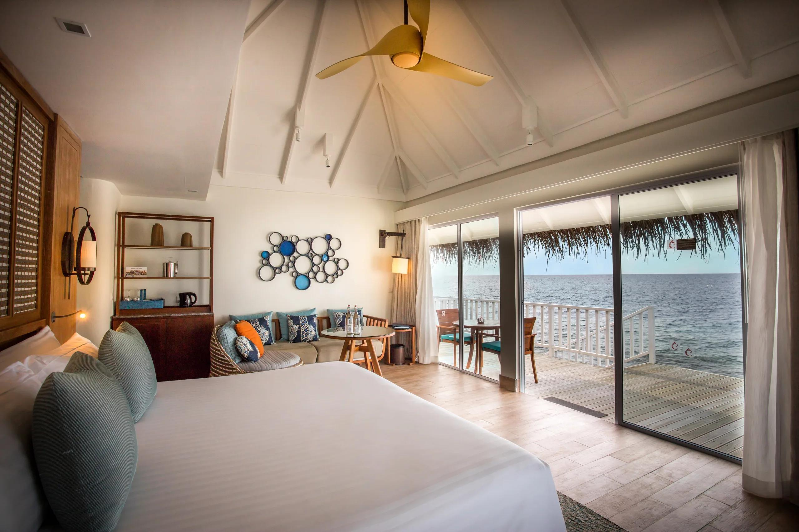 The vaulted thatched ceiling and wooden fan of a Sunrise Overwater Villa's living area