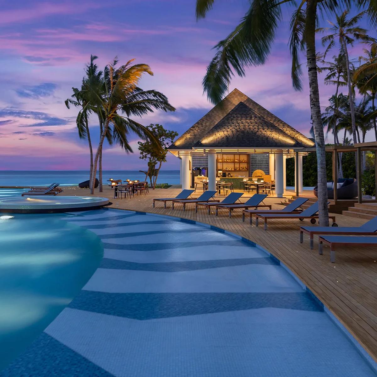 Twilight at Skipjack Poolside Bar & Restaurant — Avani+ Fares has not published a dedicated photograph of Charcoal; this evening dining scene from elsewhere on the resort stands in