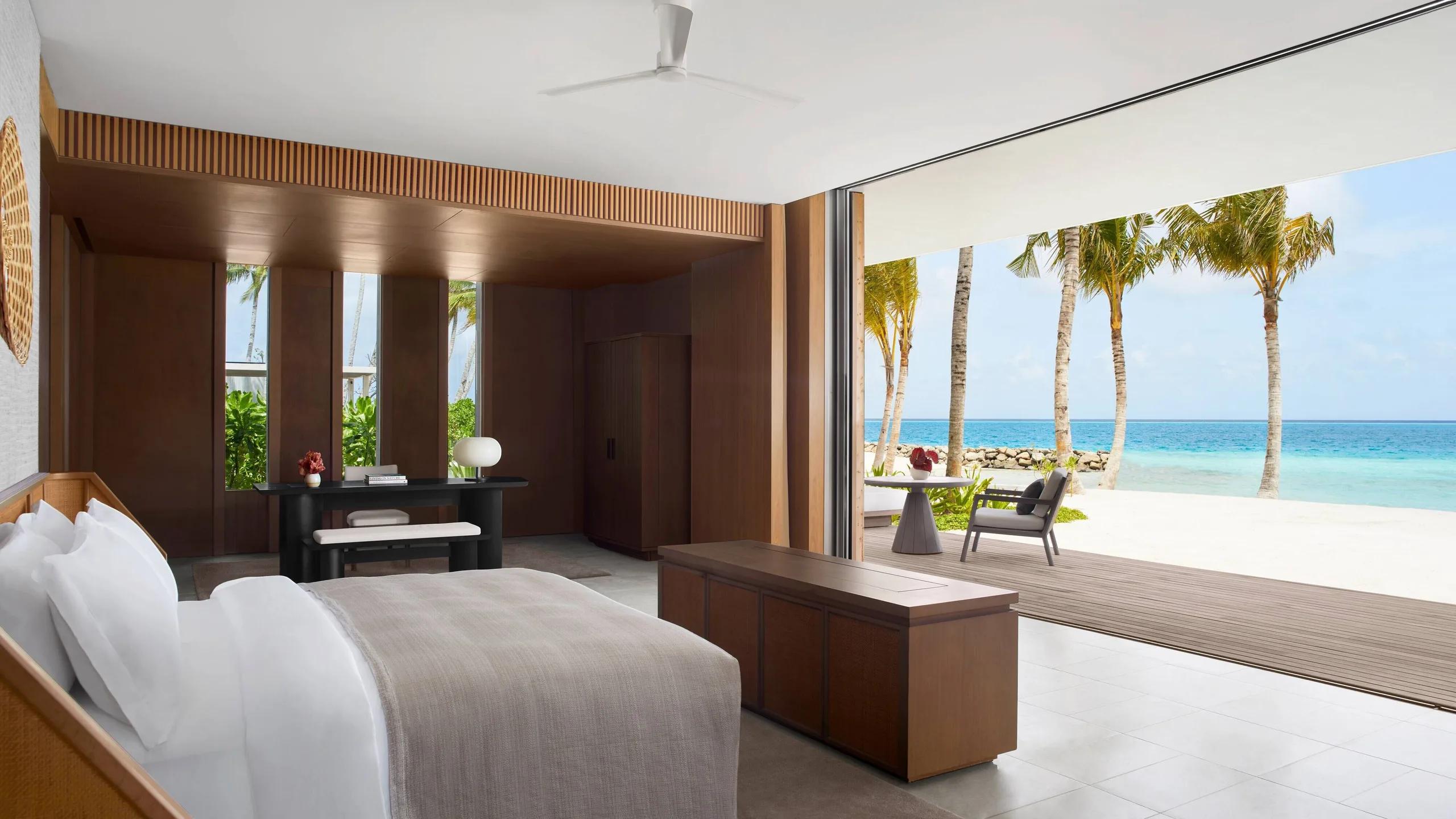 A bedroom in the Two Bedroom Overwater Villa, glass walls opening onto the sea