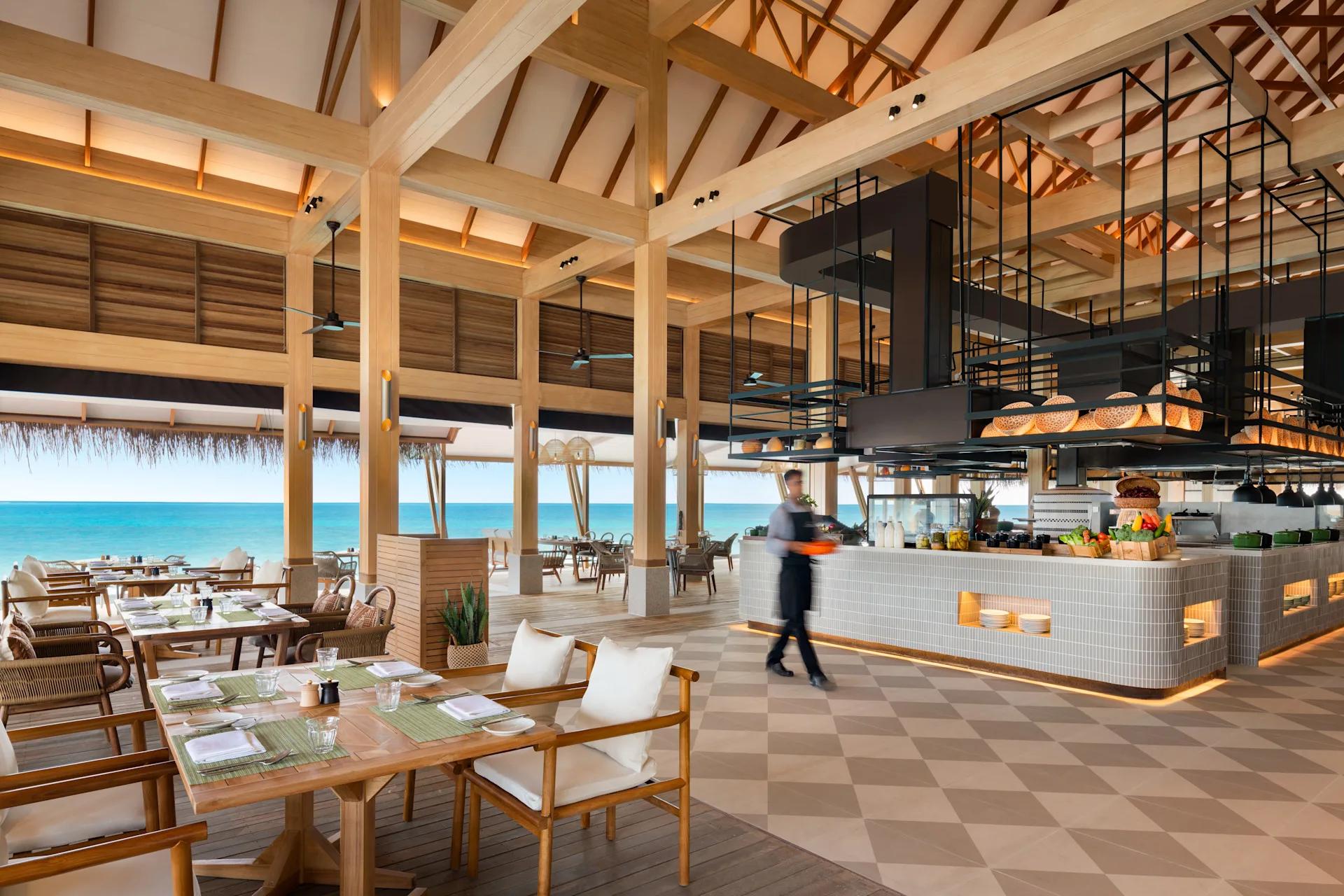The high-ceilinged, open-kitchen dining room at Habitat, set beside the sea