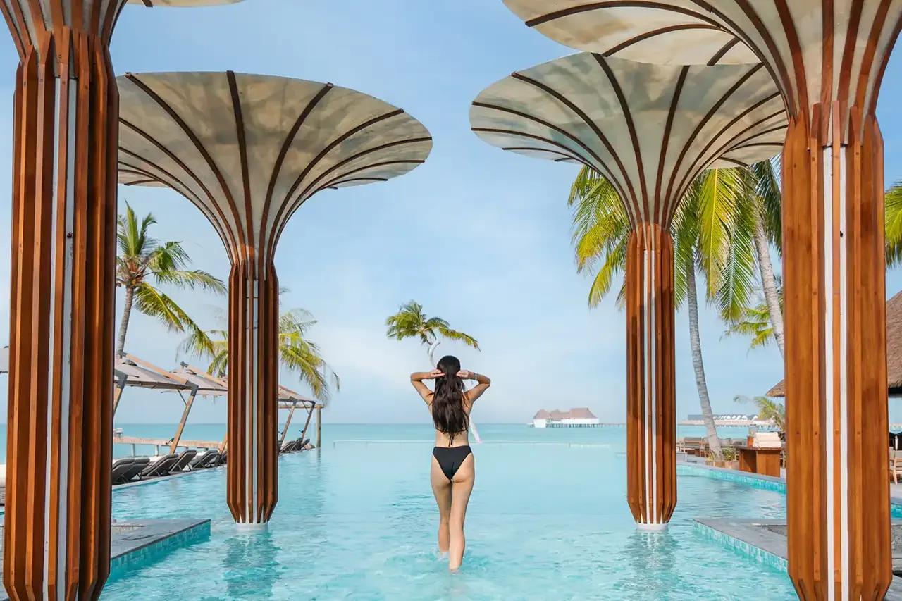 The infinity pool beside Baa, the resort's main bar, with overwater villas in the distance