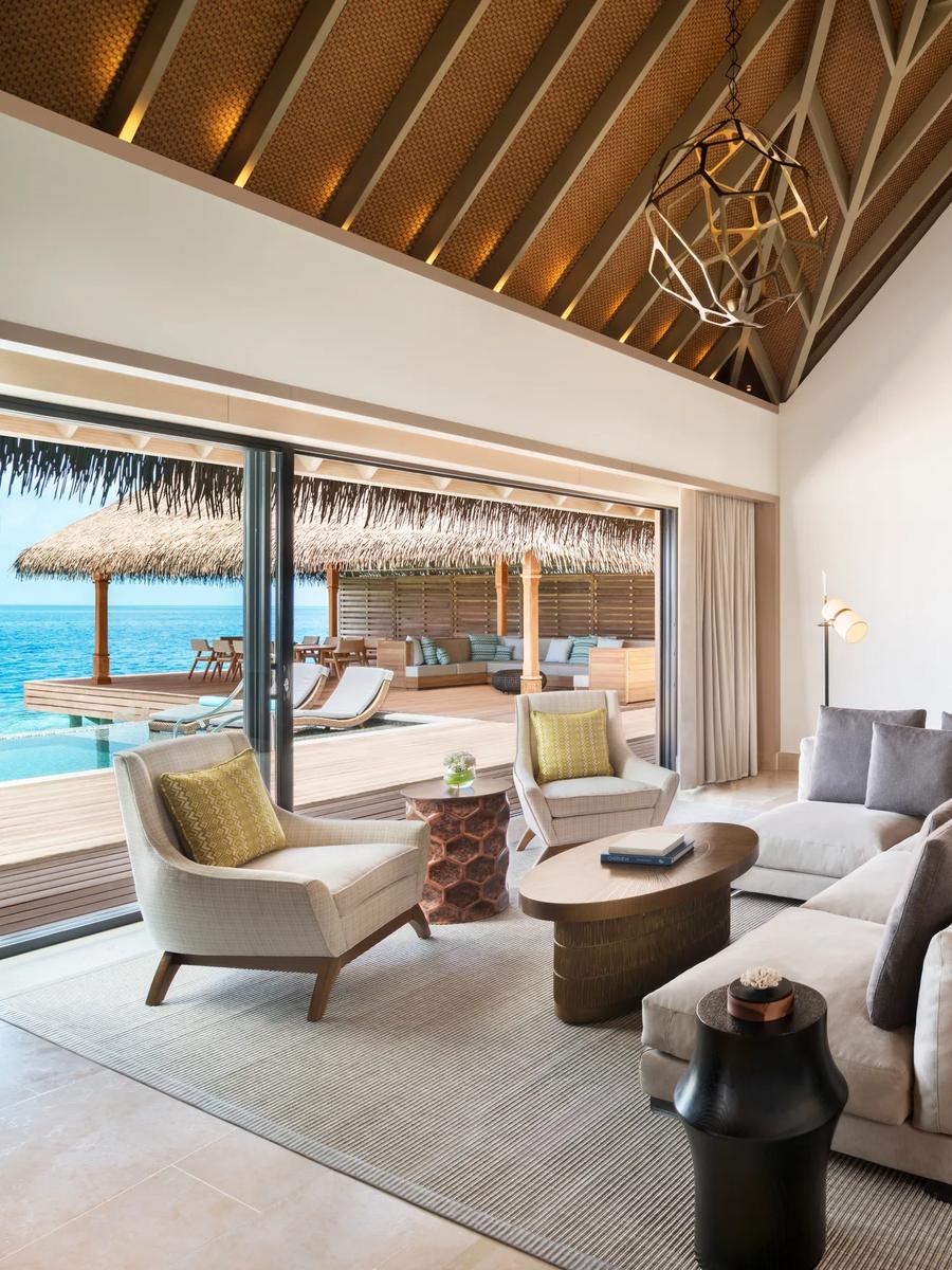The living and dining area of the Two Bedroom Overwater Villa at Waldorf Astoria Maldives Ithaafushi — the Three Bedroom Overwater Villa has no dedicated published photo, so this sibling overwater-villa image stands in here
