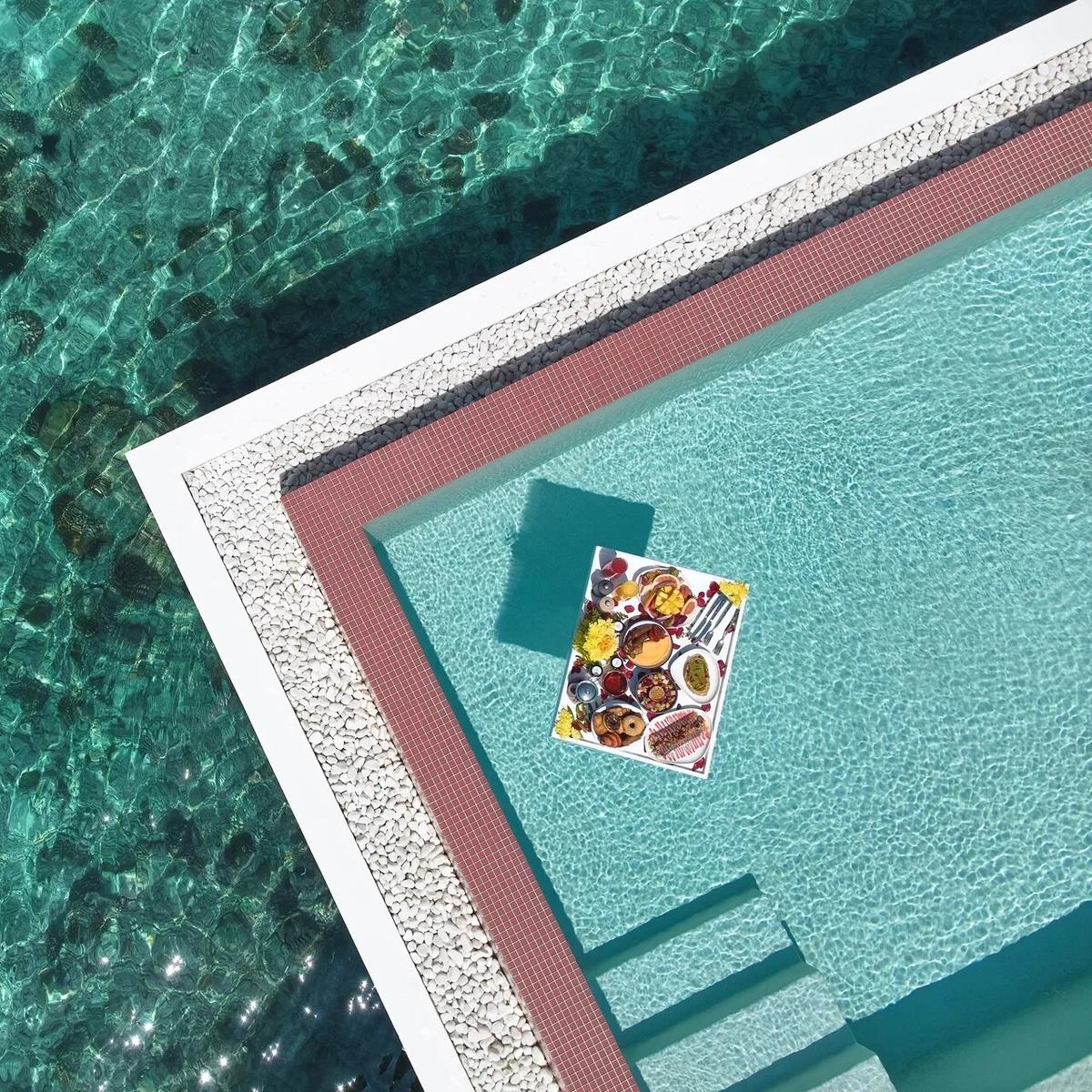 A fruit and pastry breakfast platter floating on a tray in a villa pool, seen from directly above — Gelateria has no dedicated photograph in the source material; this stands in as the closest available food-styling shot